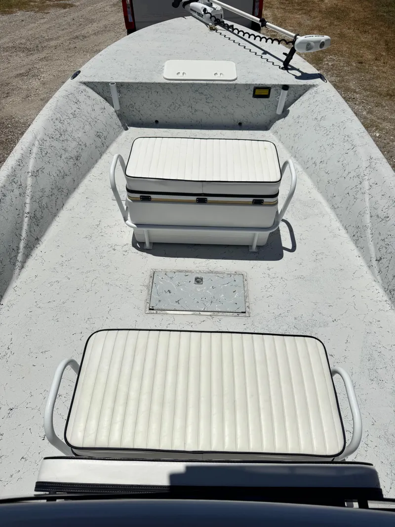Slide: The Image of 2015 Haynie 25 Magnum boat interior with white cushioned seating and storage compartments. - 6