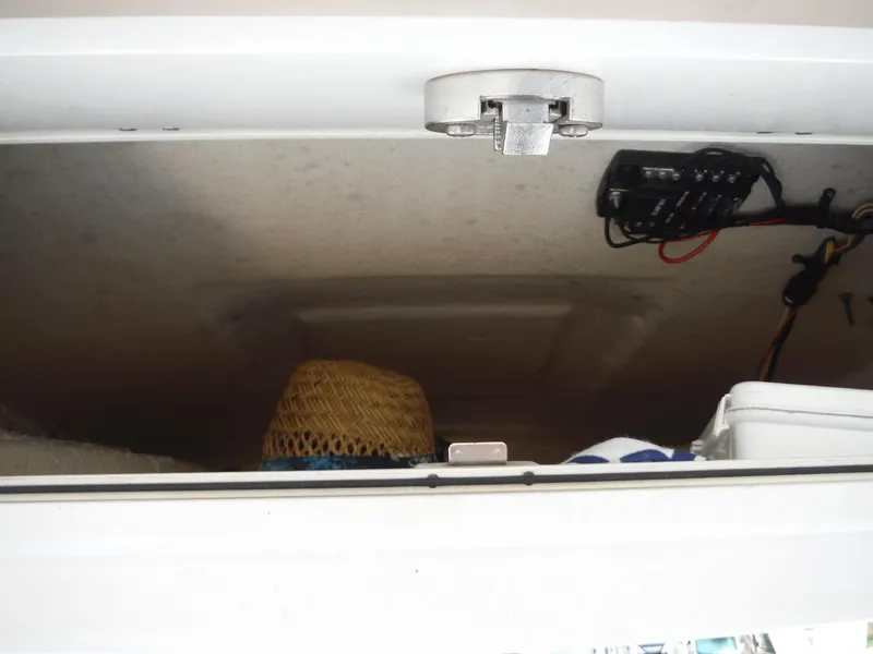 Slide: The Image of Storage compartment in a 2017 Sea Fox 266 Commander boat with wiring and a straw hat. - 24