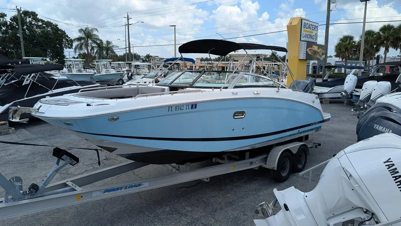The Image of 2024 Four Winns HD8 OB boat on trailer at dealership, surrounded by other boats. - 0