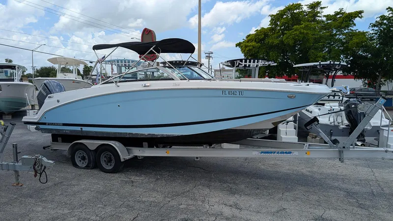 Slide: The Image of 2024 Four Winns HD8 OB boat on trailer, light blue hull, parked outdoors. - 1