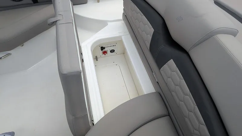 Slide: The Image of 2024 Four Winns HD8 OB boat interior storage compartment with gray seating. - 13