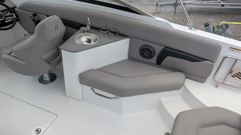 Slide: The Image of 2024 Four Winns HD8 OB boat interior with seating, sink, and steering area. - 14