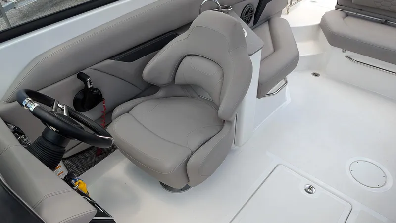 Slide: The Image of 2024 Four Winns HD8 OB boat interior with gray captain's seat and steering wheel. - 15