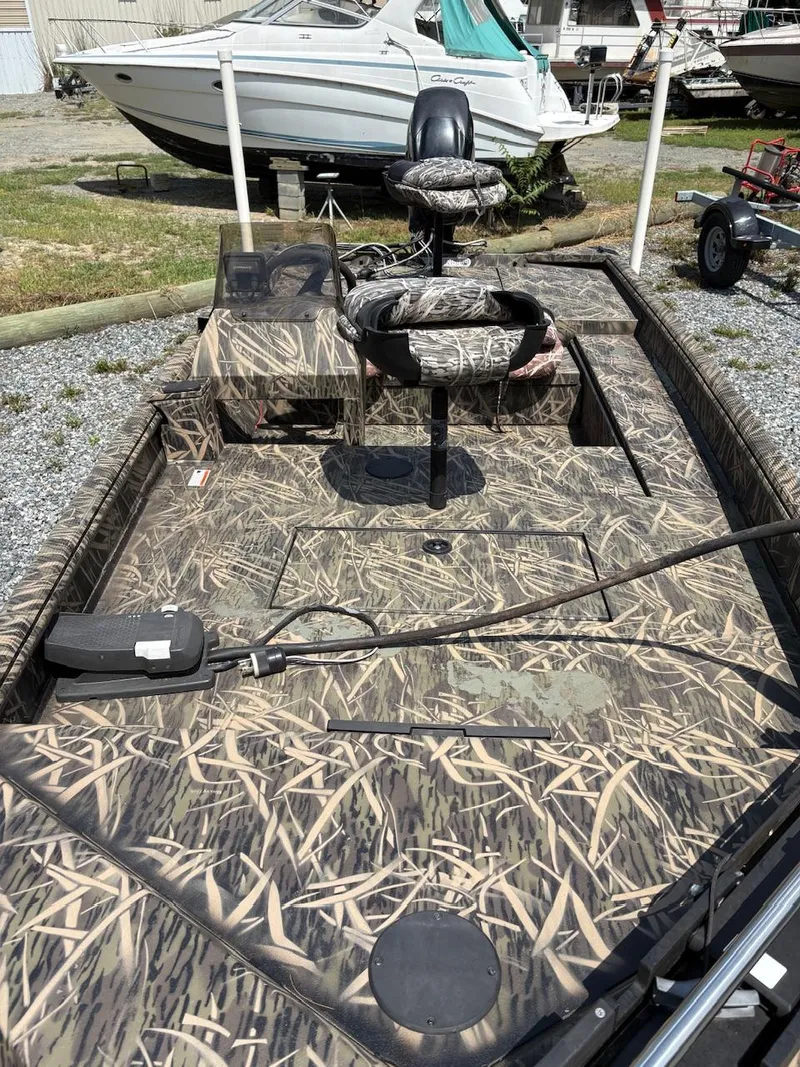 Slide: The Image of 2012 Crestliner 16 Ambush boat with camouflage design, parked outdoors. - 10