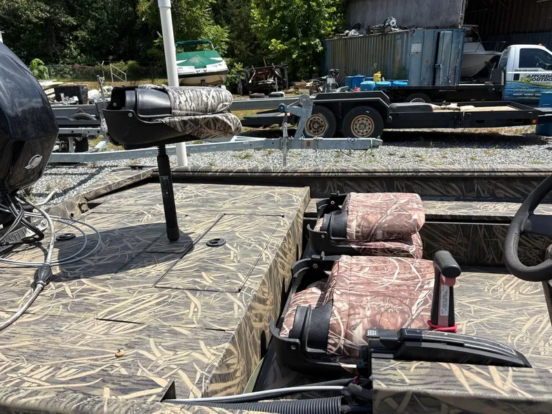 Slide: The Image of 2012 Crestliner 16 Ambush boat with camouflage seats and deck, parked outdoors. - 12