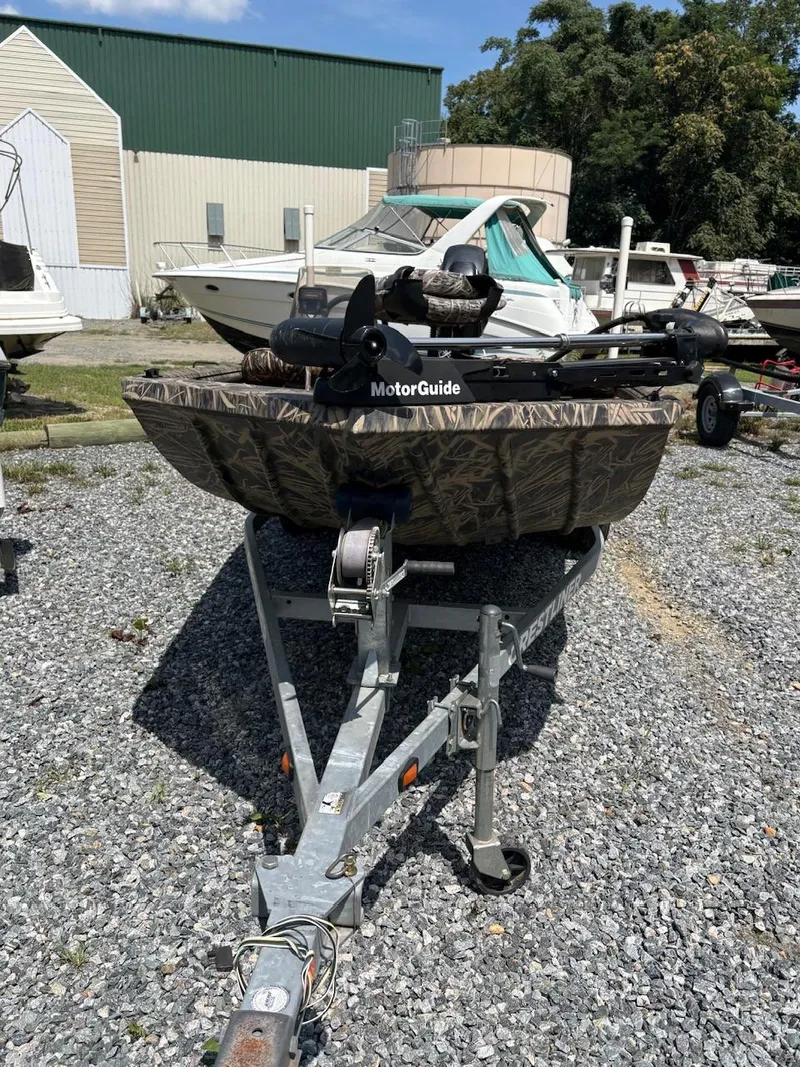 Slide: The Image of 2012 Crestliner 16 Ambush boat with MotorGuide, parked on gravel lot. - 13
