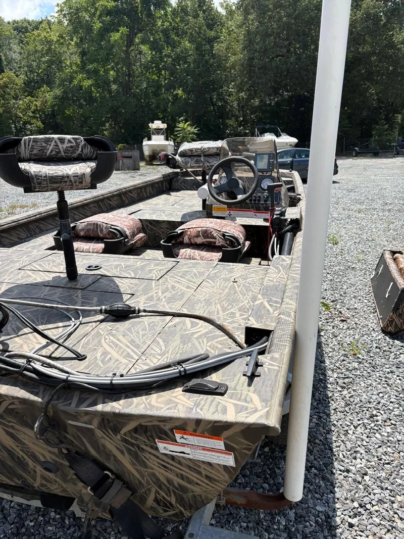 Slide: The Image of 2012 Crestliner 16 Ambush boat with camouflage design, parked on gravel. - 7