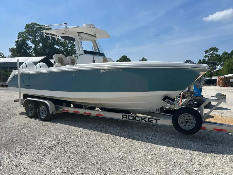Slide: The Image of 2019 Edgewater 262CC boat on trailer, parked outdoors under clear sky. - 0