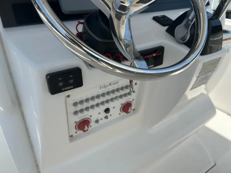 Slide: The Image of Control panel of a 2019 Edgewater 262CC boat with steering wheel and Yamaha controls. - 12