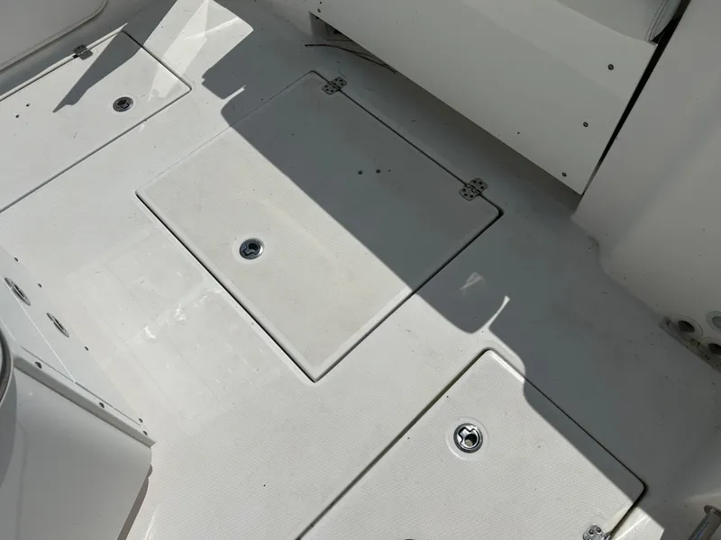 Slide: The Image of 2019 Edgewater 262CC boat deck with storage compartments and clean white surface. - 7