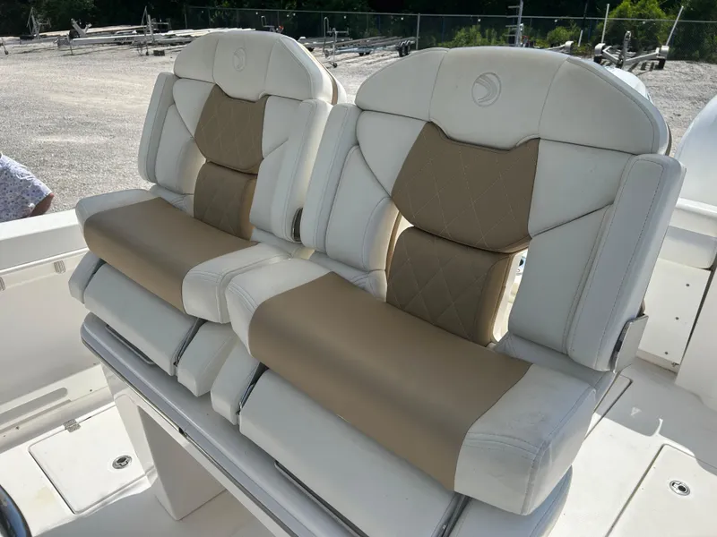 Slide: The Image of 2019 Edgewater 262CC boat seats with beige and white upholstery, featuring diamond stitching. - 9