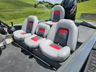 Slide: The Image of 2016 Tracker Pro Team 190 TX boat seats with red accents, set against a grassy landscape. - 10