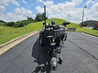Slide: The Image of 2016 Tracker Pro Team 190 TX boat on trailer, parked on asphalt, with grassy hills in background. - 6