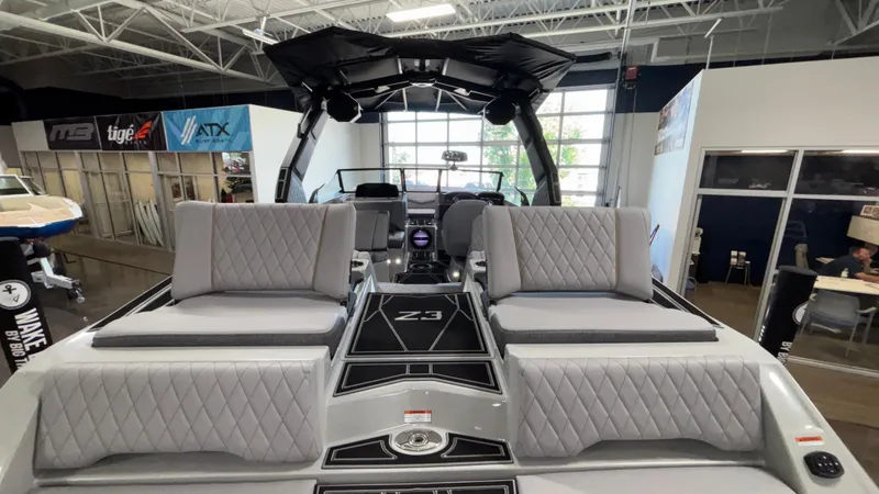 Slide: The Image of 2026 Tigé Z3 boat interior with gray quilted seats in a showroom. - 8