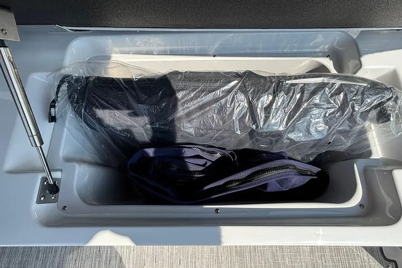 Slide: The Image of Storage compartment in 2026 Cobalt R6 Outboard boat, featuring protective cover and bag. - 11