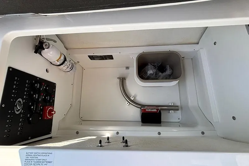 Slide: The Image of 2026 Cobalt R6 Outboard storage compartment with fire extinguisher and control panel. - 12