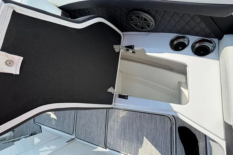 Slide: The Image of Open storage compartment on 2026 Cobalt R6 Outboard boat with cup holders and speaker. - 20