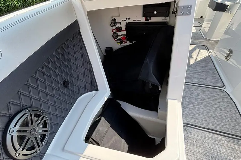 Slide: The Image of Storage compartment of 2026 Cobalt R6 Outboard boat with speaker and wiring. - 22