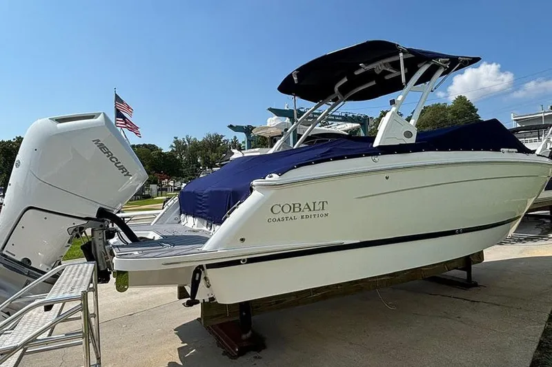 Slide: The Image of 2026 Cobalt R6 Outboard boat with Mercury engine, docked under clear blue sky. - 4