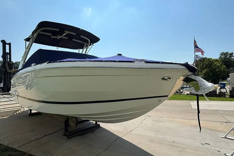 Slide: The Image of 2026 Cobalt R6 Outboard boat on display, covered and elevated, with clear blue sky. - 6