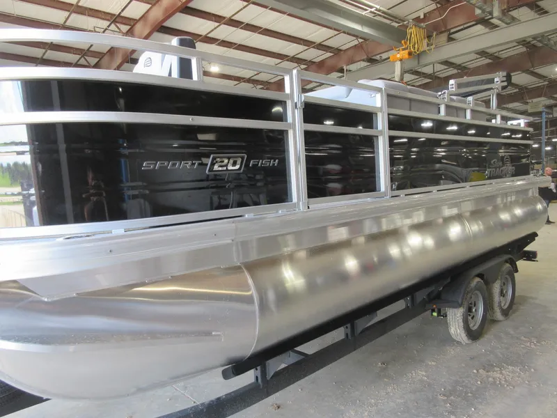 Slide: The Image of 2026 Sun Tracker SportFish 20 DLX pontoon boat in a warehouse setting. - 2