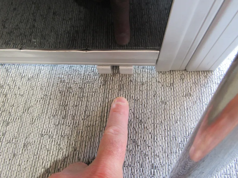 Slide: The Image of Finger pointing at a latch on a 2026 Sun Tracker SportFish 20 DLX boat. - 8