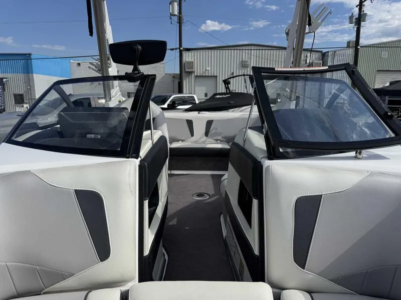 Slide: The Image of 2017 Malibu Wakesetter 20 VTX interior with white and gray seating, open windshield, and outdoor setting. - 13