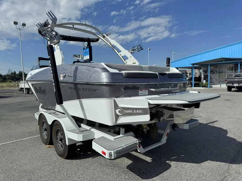 Slide: The Image of 2017 Malibu Wakesetter 20 VTX boat on trailer in parking lot, under clear sky. - 7