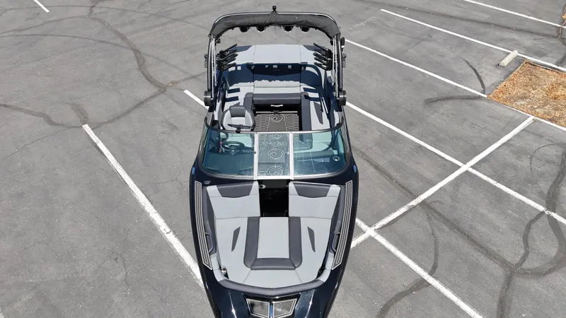 Slide: The Image of 2025 MasterCraft NXT22 boat, aerial view in parking lot, showcasing sleek design and seating layout. - 17