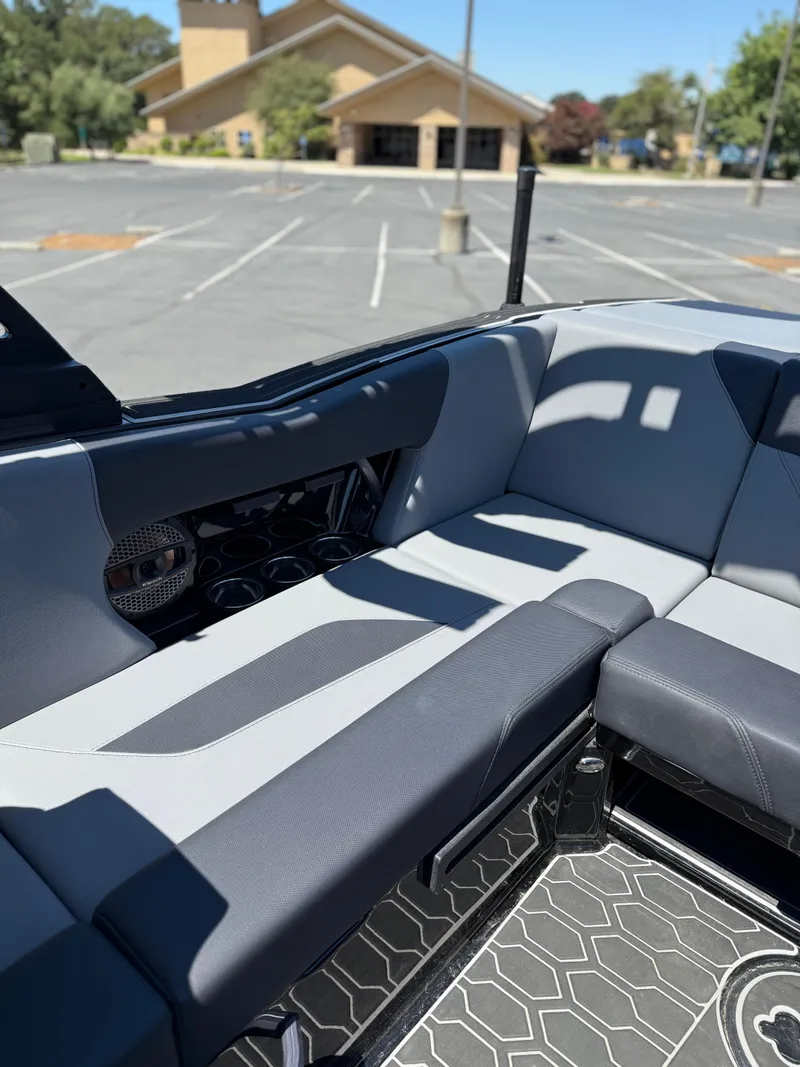 Slide: The Image of 2025 MasterCraft NXT22 boat interior with gray seating and geometric flooring. - 21