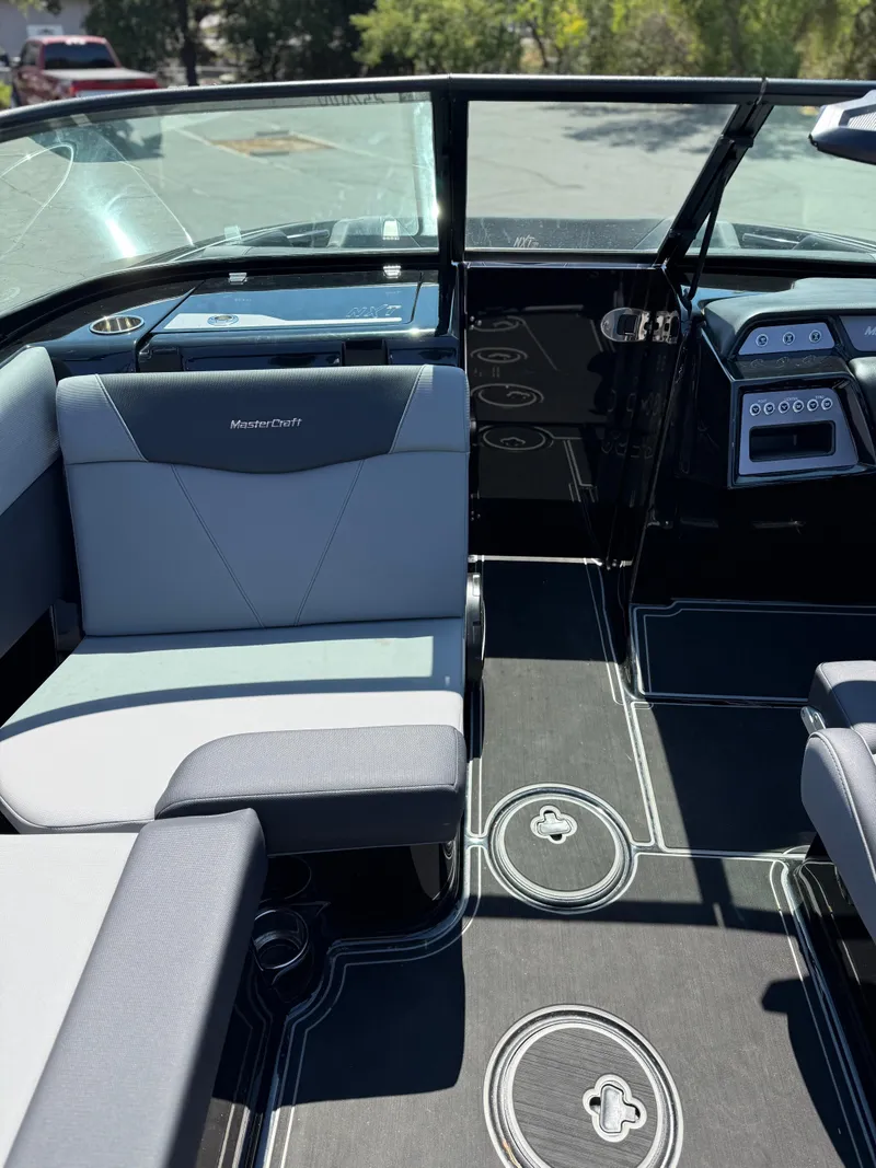 Slide: The Image of 2025 MasterCraft NXT22 boat interior with sleek seating and modern dashboard design. - 27