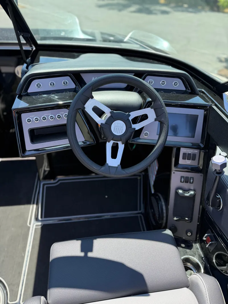 Slide: The Image of Interior of 2025 MasterCraft NXT22 boat, featuring modern steering wheel and dashboard controls. - 29