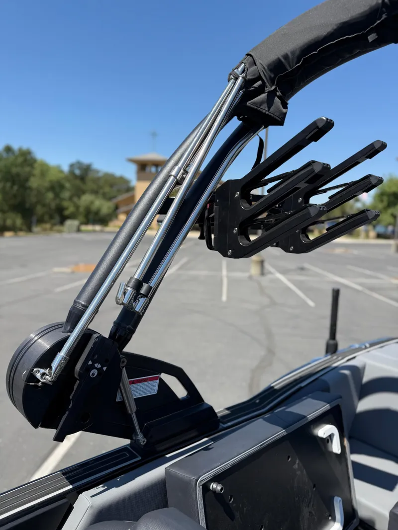 Slide: The Image of 2025 MasterCraft NXT22 boat tower with wakeboard rack in a parking lot. - 31