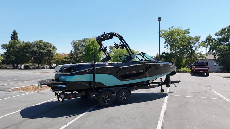 Slide: The Image of 2025 MasterCraft NXT22 boat on trailer in parking lot, sunny day. - 4