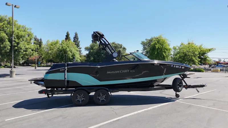 Slide: The Image of 2025 MasterCraft NXT22 boat on trailer in parking lot, sunny day. - 5