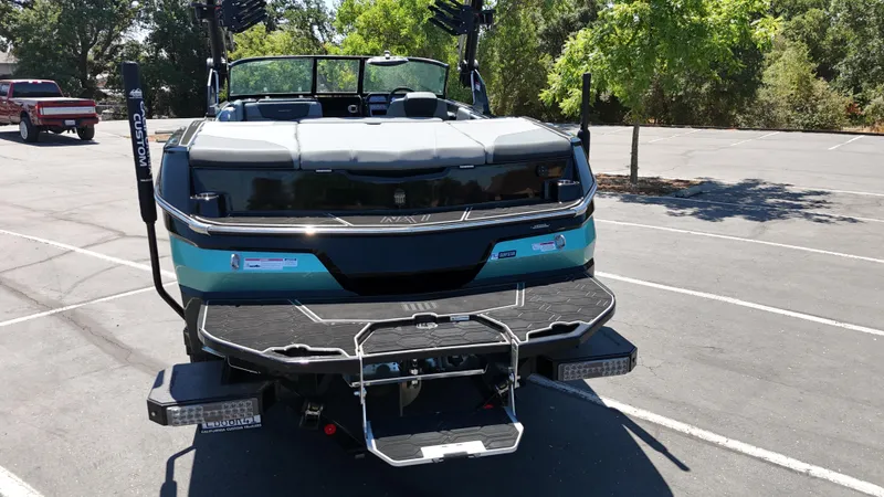 Slide: The Image of 2025 MasterCraft NXT22 boat in parking lot, rear view with swim platform. - 6