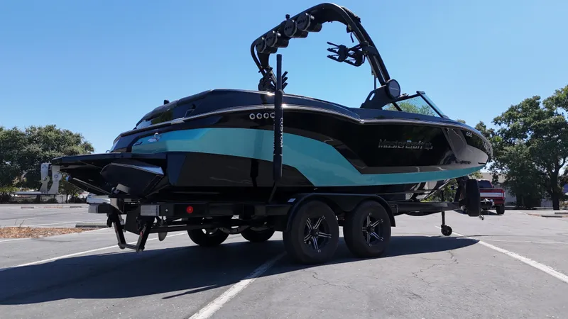 Slide: The Image of 2025 MasterCraft NXT22 boat on trailer in parking lot, side view. - 7