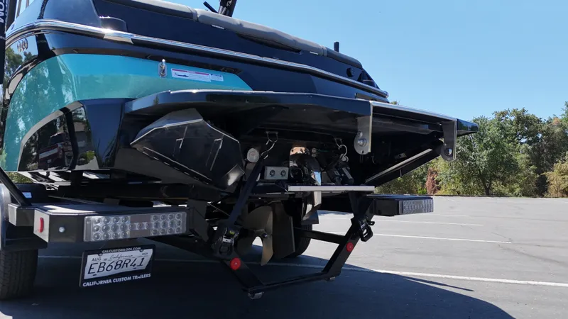 Slide: The Image of 2025 MasterCraft NXT22 boat on trailer, rear view, parked outdoors. - 8