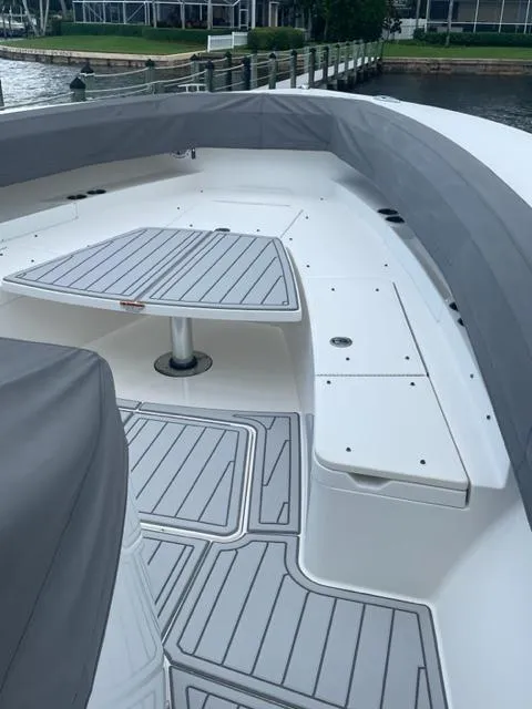Slide: The Image of 2018 Regulator 41 boat deck with seating and table, docked by the water. - 11