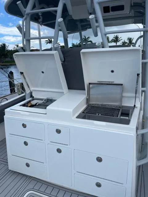 Slide: The Image of 2018 Regulator 41 boat with open storage compartments and grill on deck. - 14