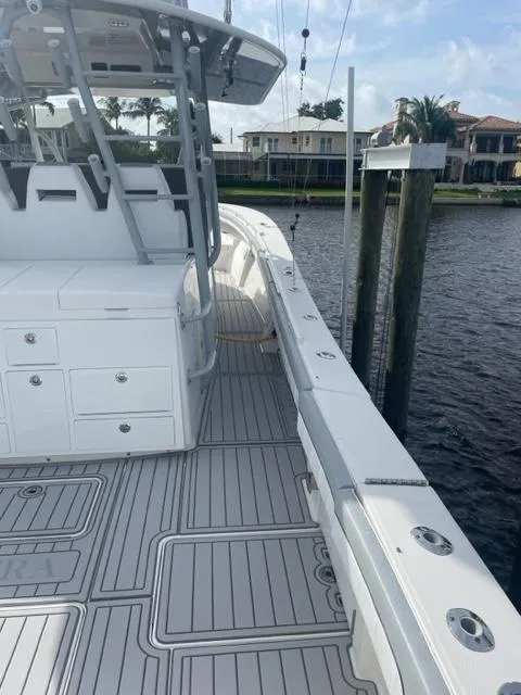 Slide: The Image of 2018 Regulator 41 boat docked by waterfront homes, featuring spacious deck and modern design. - 18
