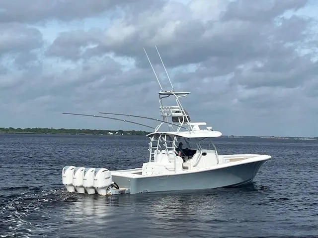Slide: The Image of 2018 Regulator 41 boat with four engines cruising on open water under cloudy skies. - 2