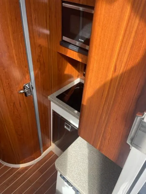 Slide: The Image of 2018 Regulator 41 interior with wood finish, compact kitchen, and modern appliances. - 23