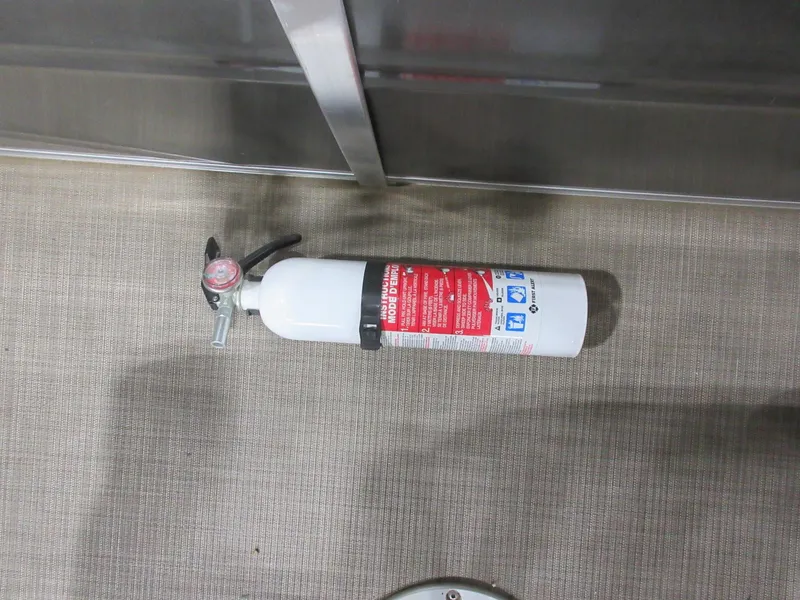 Slide: The Image of Fire extinguisher on 2024 Sun Tracker Fishin' Barge 20 DLX boat floor. - 11
