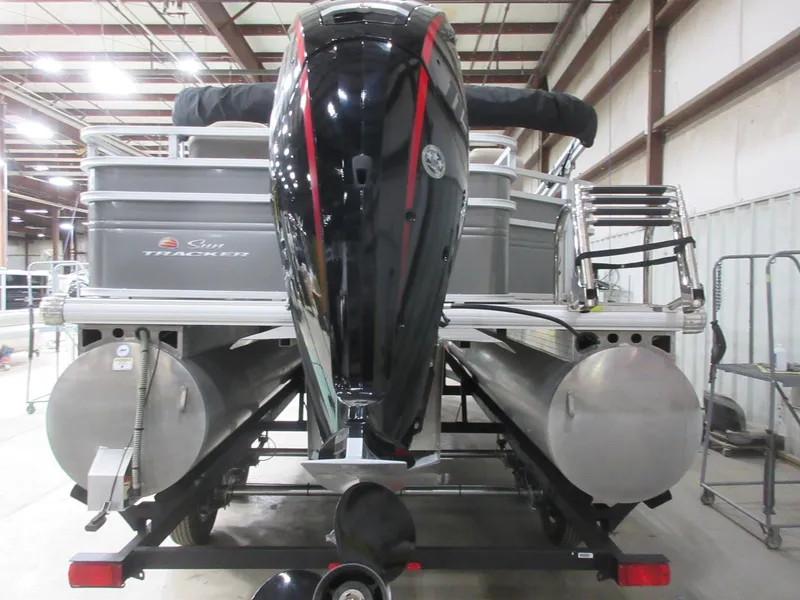 Slide: The Image of 2024 Sun Tracker Fishin' Barge 20 DLX pontoon boat in warehouse, rear view. - 3
