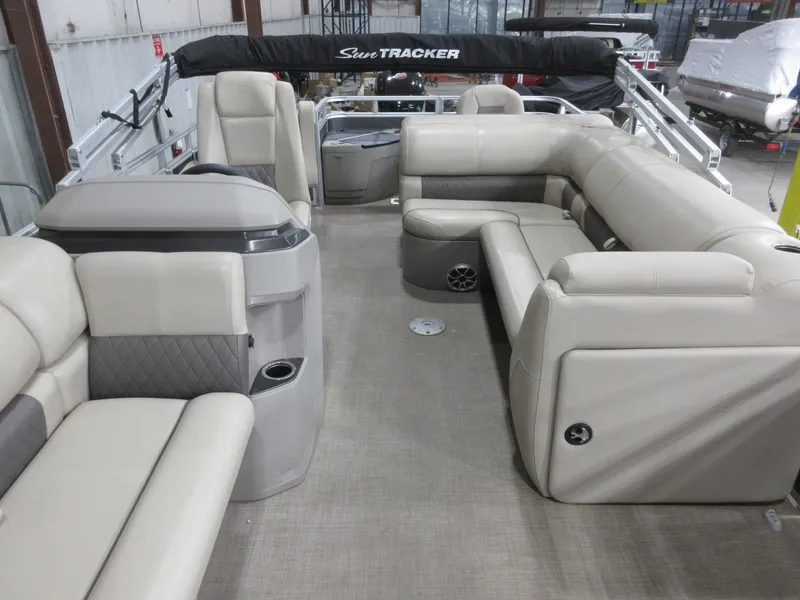 Slide: The Image of 2024 Sun Tracker Fishin' Barge 20 DLX interior with beige seating and spacious layout. - 8