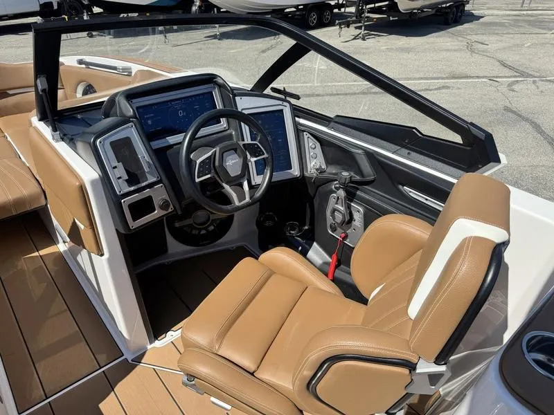 Slide: The Image of 2023 Supra SA boat cockpit with modern controls and tan leather seating. - 13