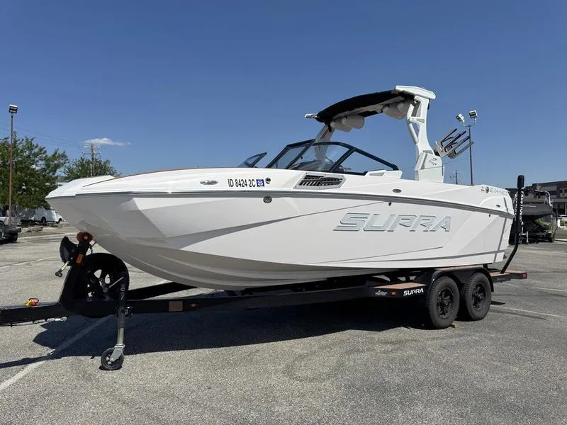 Slide: The Image of 2023 Supra SA boat on trailer in parking lot under clear blue sky. - 3