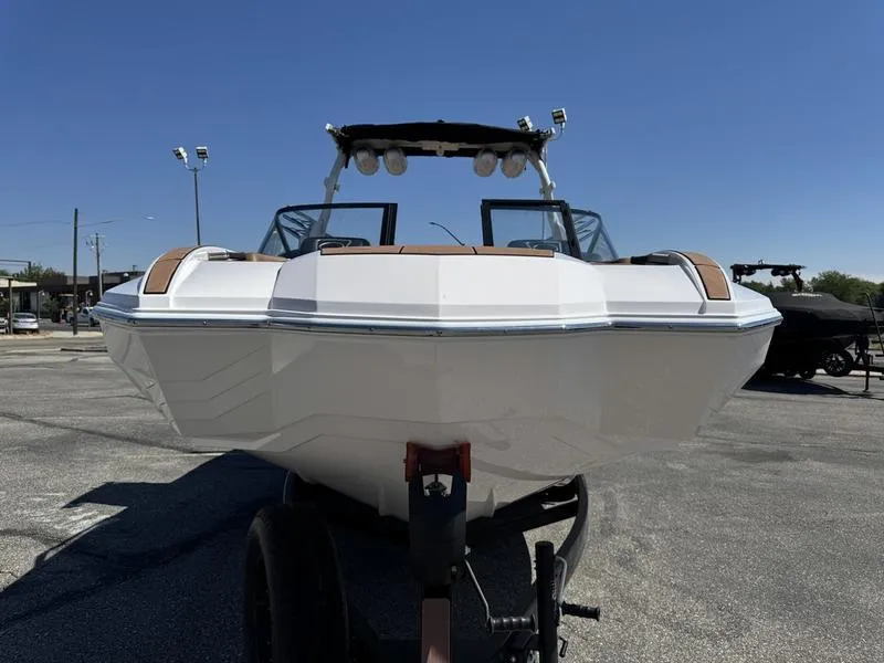 Slide: The Image of 2023 Supra SA boat on trailer, front view, in a parking lot under clear blue sky. - 6
