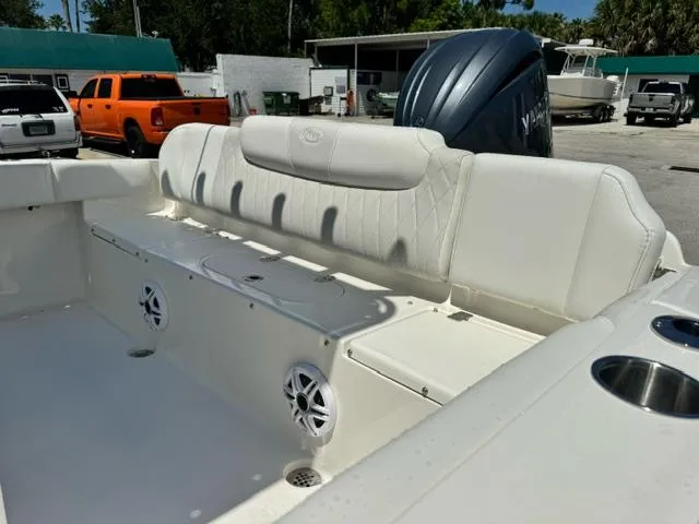 Slide: The Image of 2026 Key West 219 FS boat interior with cushioned seating and speakers, parked outdoors. - 10